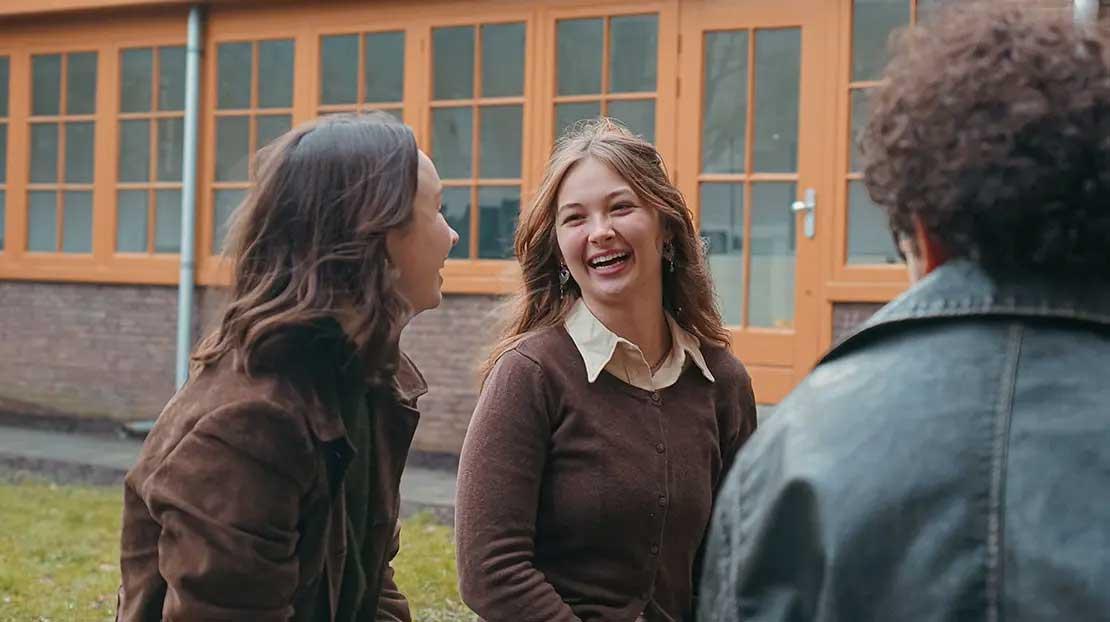 Students talking and laughing outside the dormitory