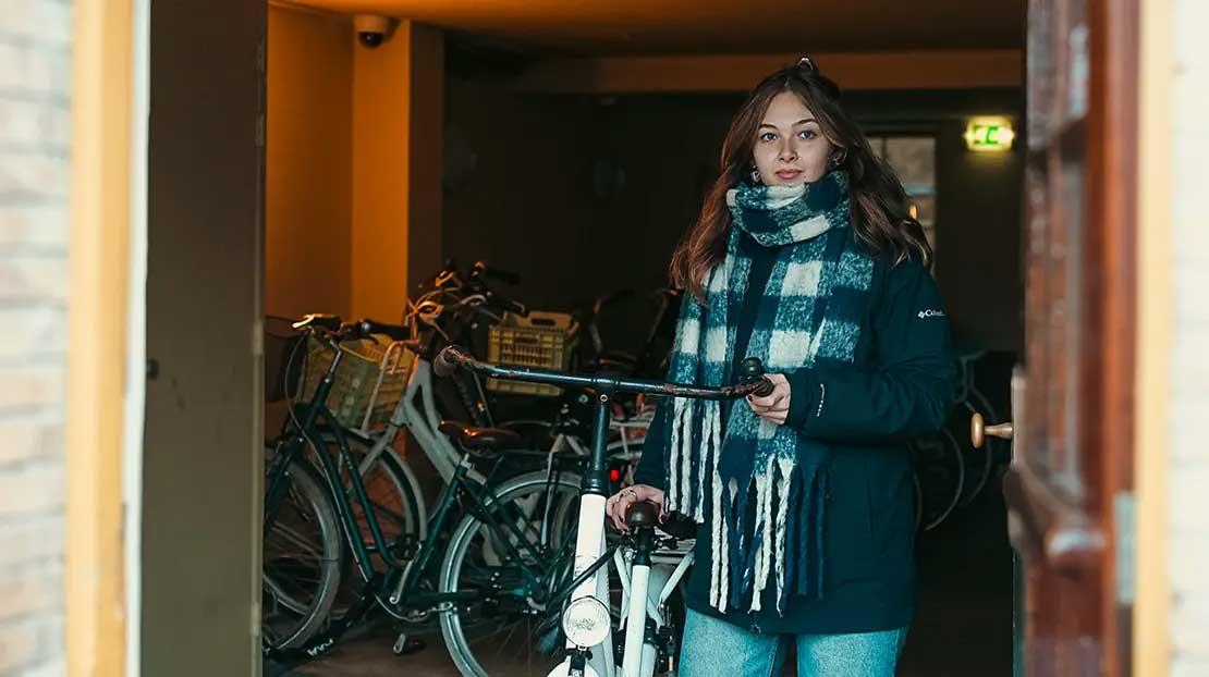 Student using a bike from the dorm bike shed.